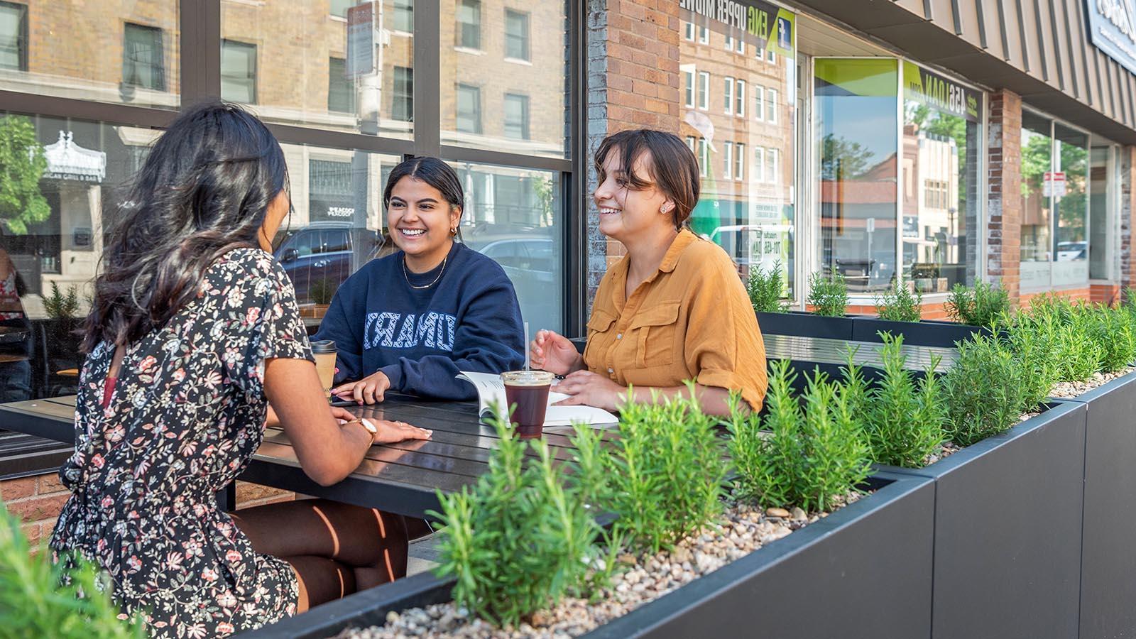 三个快乐的大学生在俾斯麦市中心的一家咖啡店里喝咖啡.